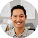 Small business owner smiling in a modern office with a signed contract folder